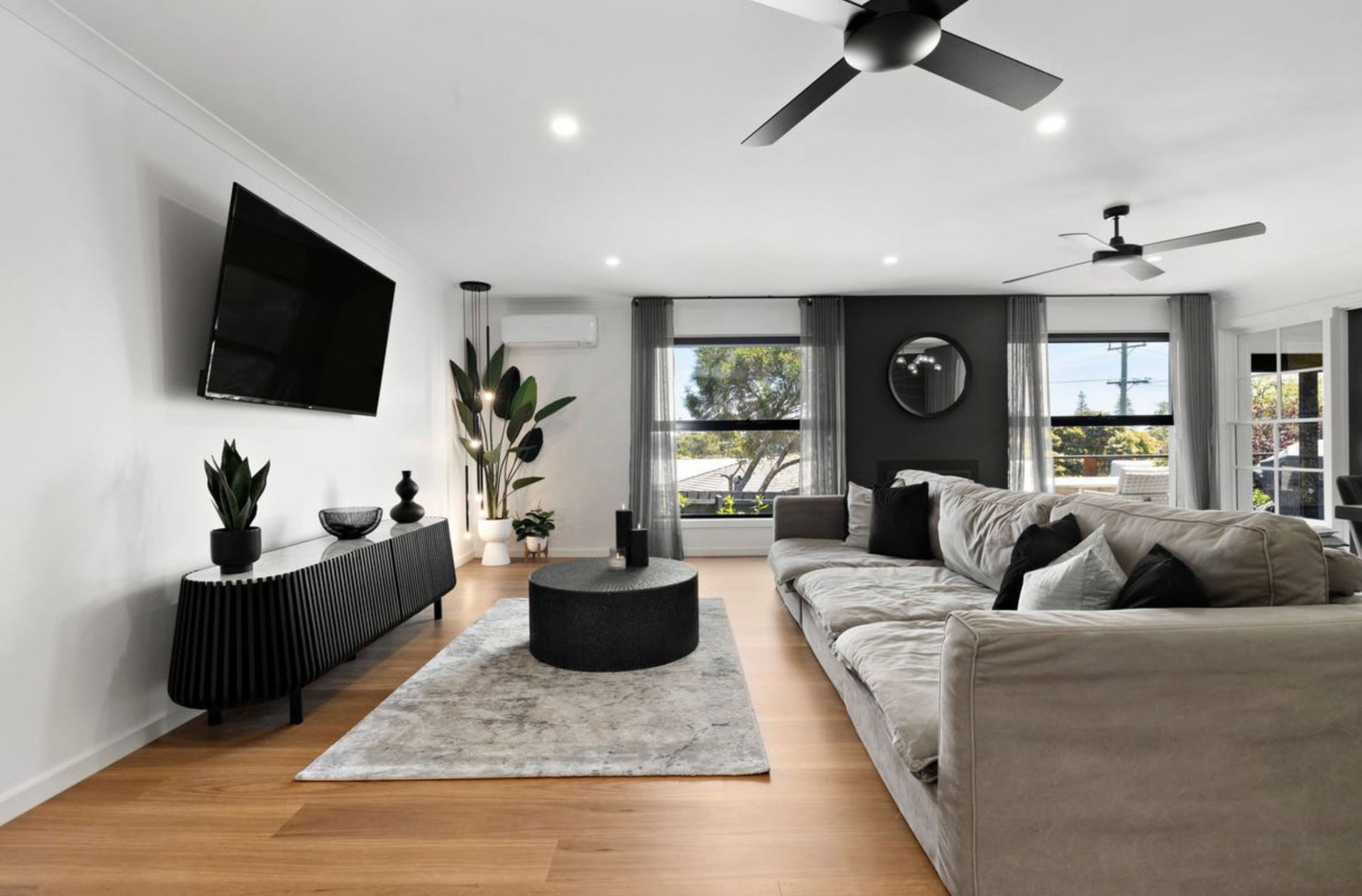 Living room with gray sofa, black entertainment center, rug, and black coffee table.