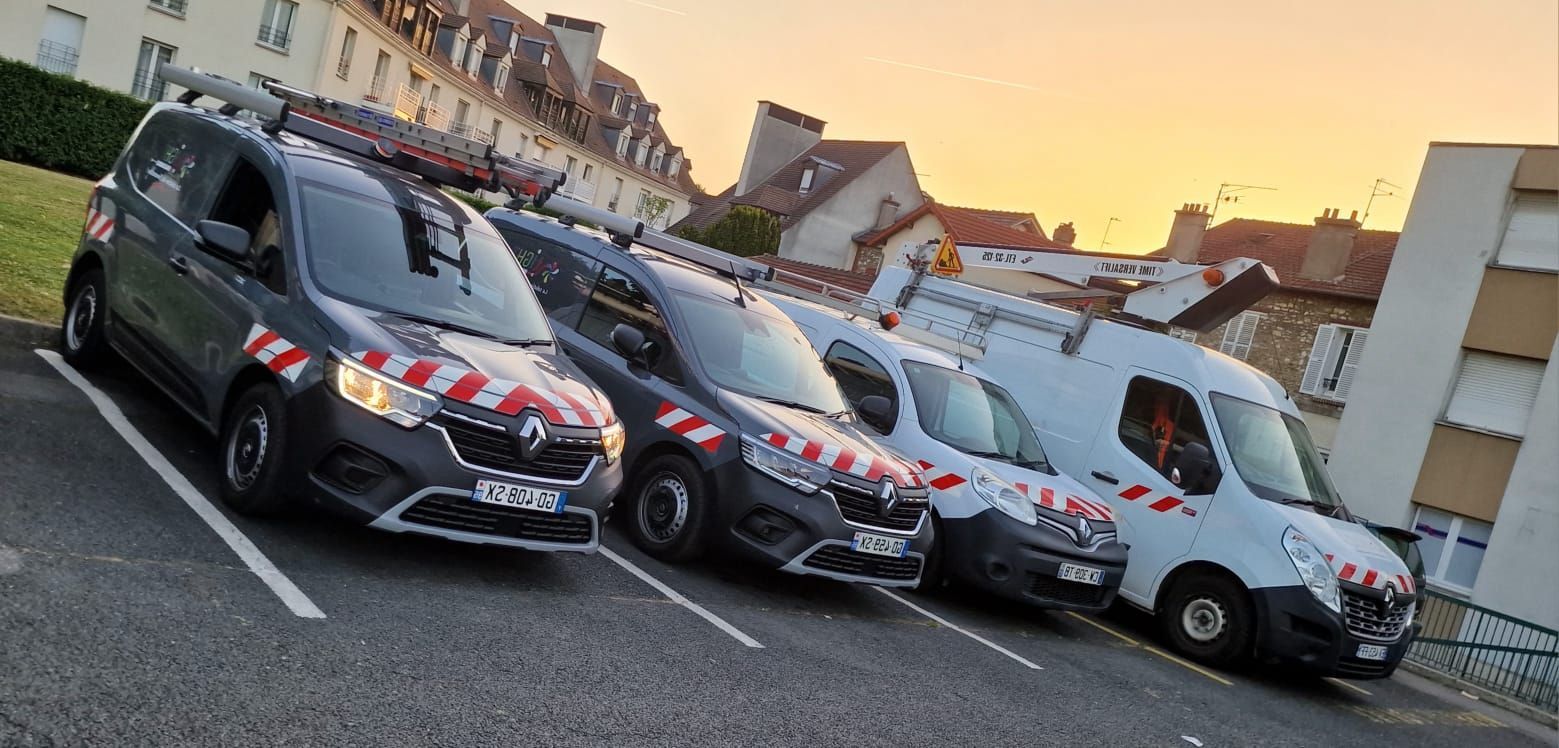 Une rangée de camionnettes est garée dans un parking.