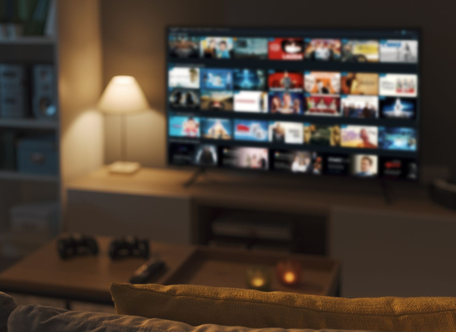 Cozy living room with a lit lamp and TV displaying a streaming movie grid