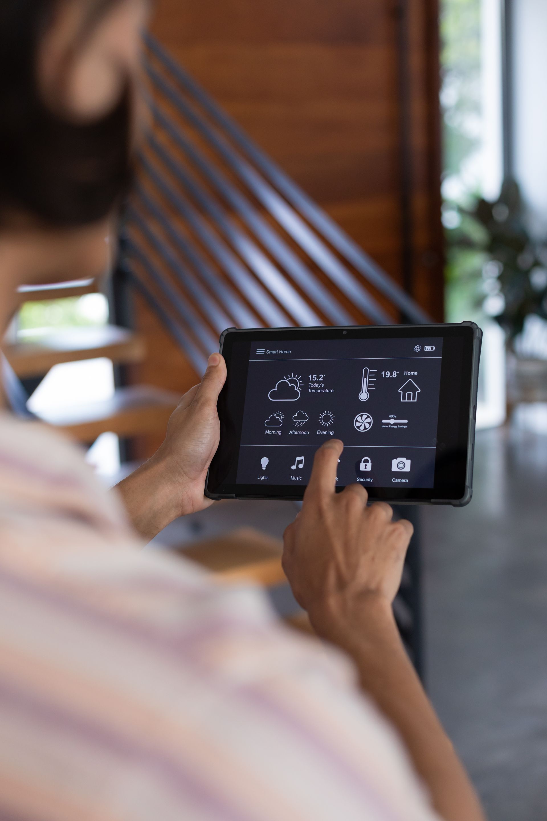 Person using a tablet with a dark control dashboard in a modern indoor setting