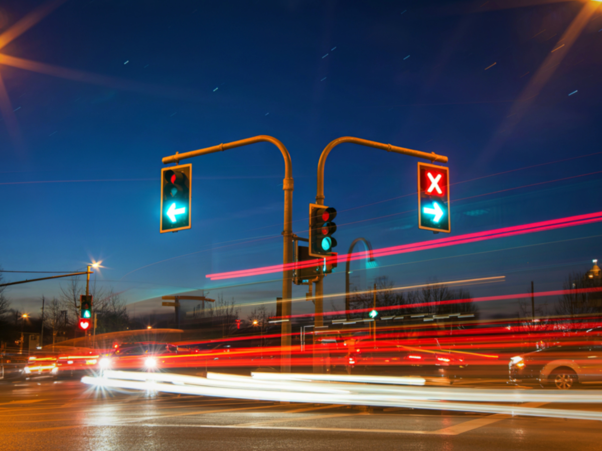 Traffic lights at dusk with light trails from passing cars at an intersection