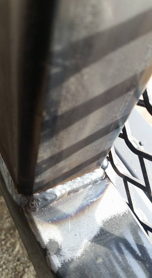 Close-up of a striped black post mounted on a metal base with bright sunlight reflections.