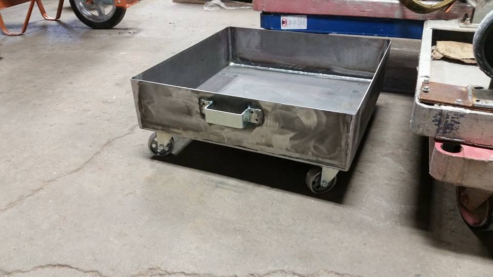 Metal utility cart with a large gray bin on casters in a workshop or warehouse setting