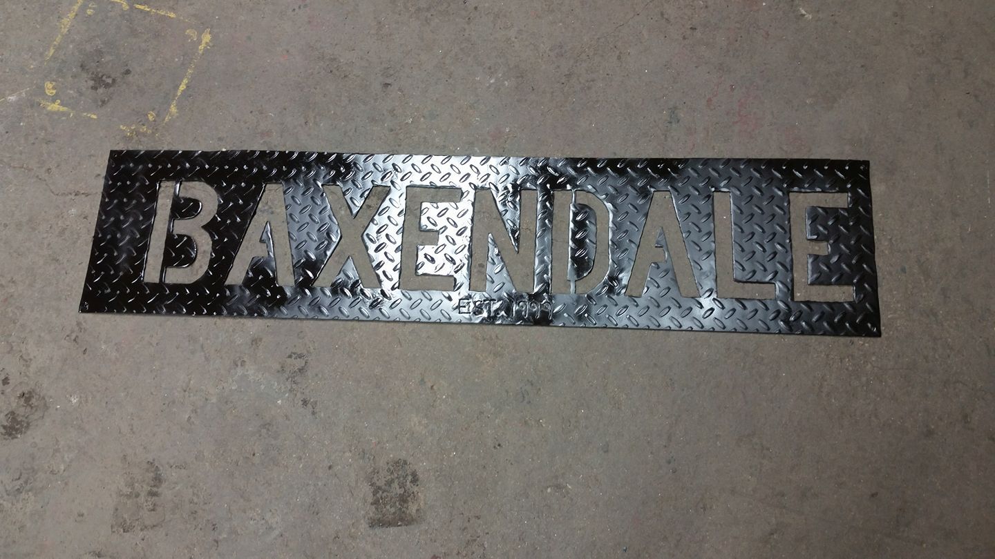 Black “BAXENDALE” nameplate on a concrete surface