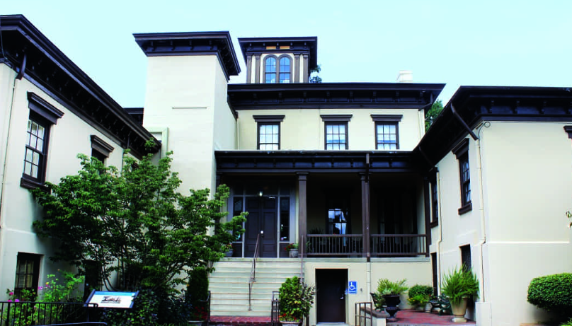 A large white house with a porch and stairs