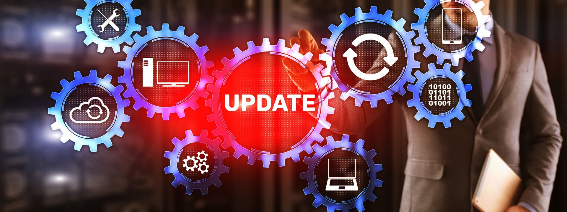 A man in a suit is standing in front of a screen that says update.