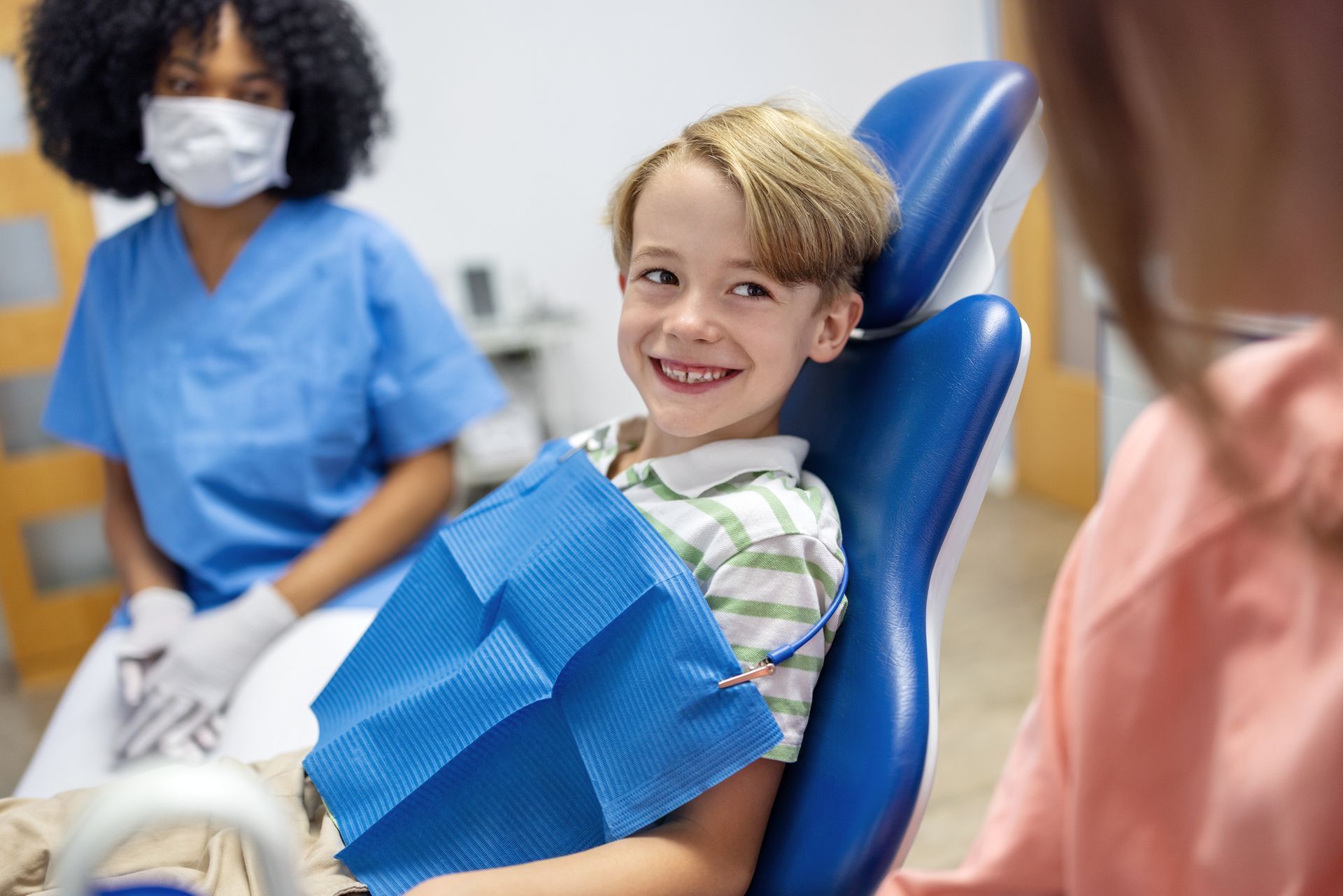Happy young boy smiling at his mother after a dental procedure.