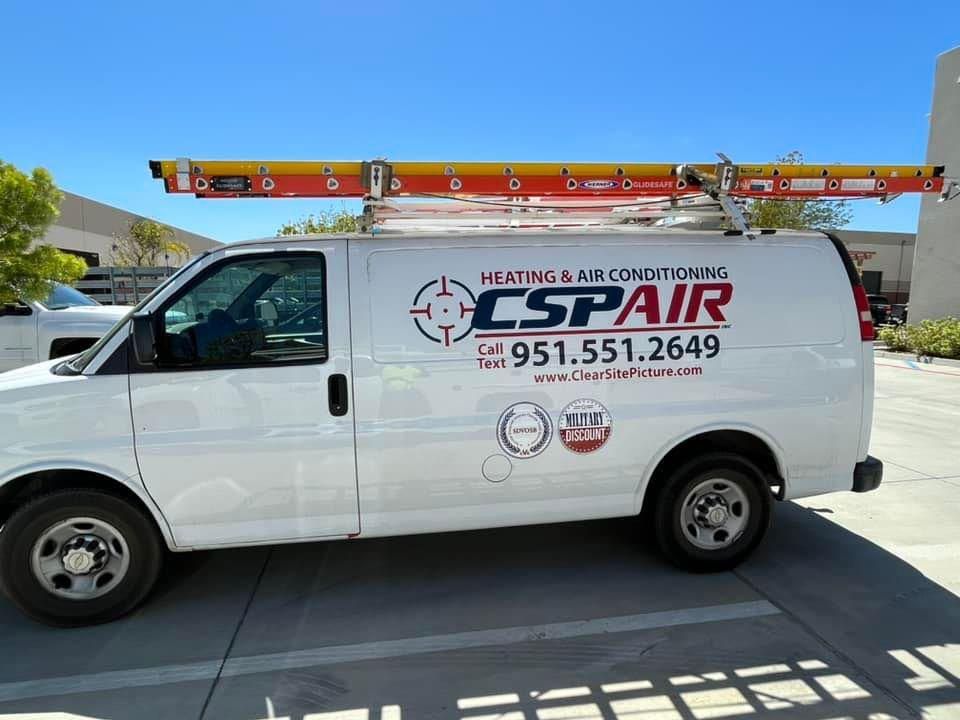 A cspair van with a ladder on top of it