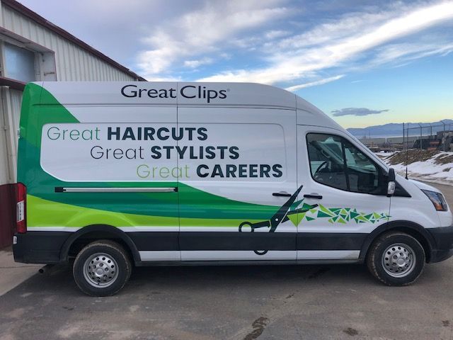 White Great Clips van with green and blue accents, parked by a building. Text reads: Great Haircuts, Stylists, and Careers.