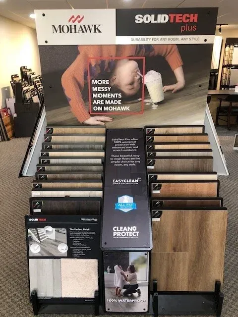 Mohawk SolidTech Plus flooring display in a store, showing samples of various colors and styles.