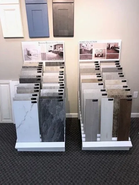 Tile samples displayed on two white stands with cabinet door samples above.
