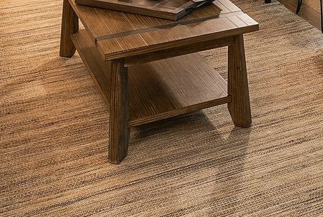 Wooden coffee table with a lower shelf, on a neutral-toned woven rug.