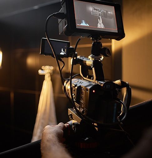 A person is holding a video camera with a monitor attached to it