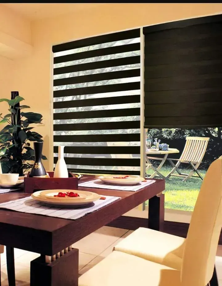 Dining room with striped shade, dark solid shade, table set for two, view of outdoor patio.