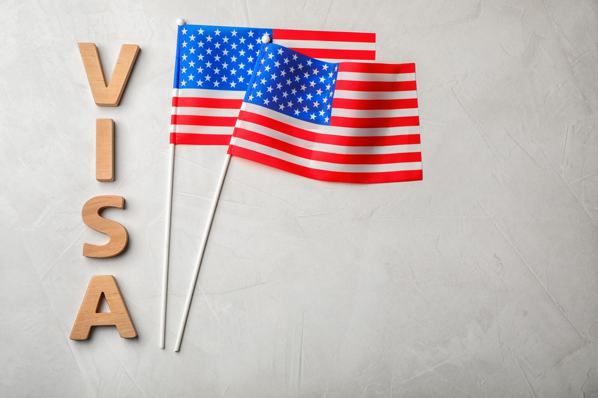 US visa text beside two crossed American flags on a light gray background