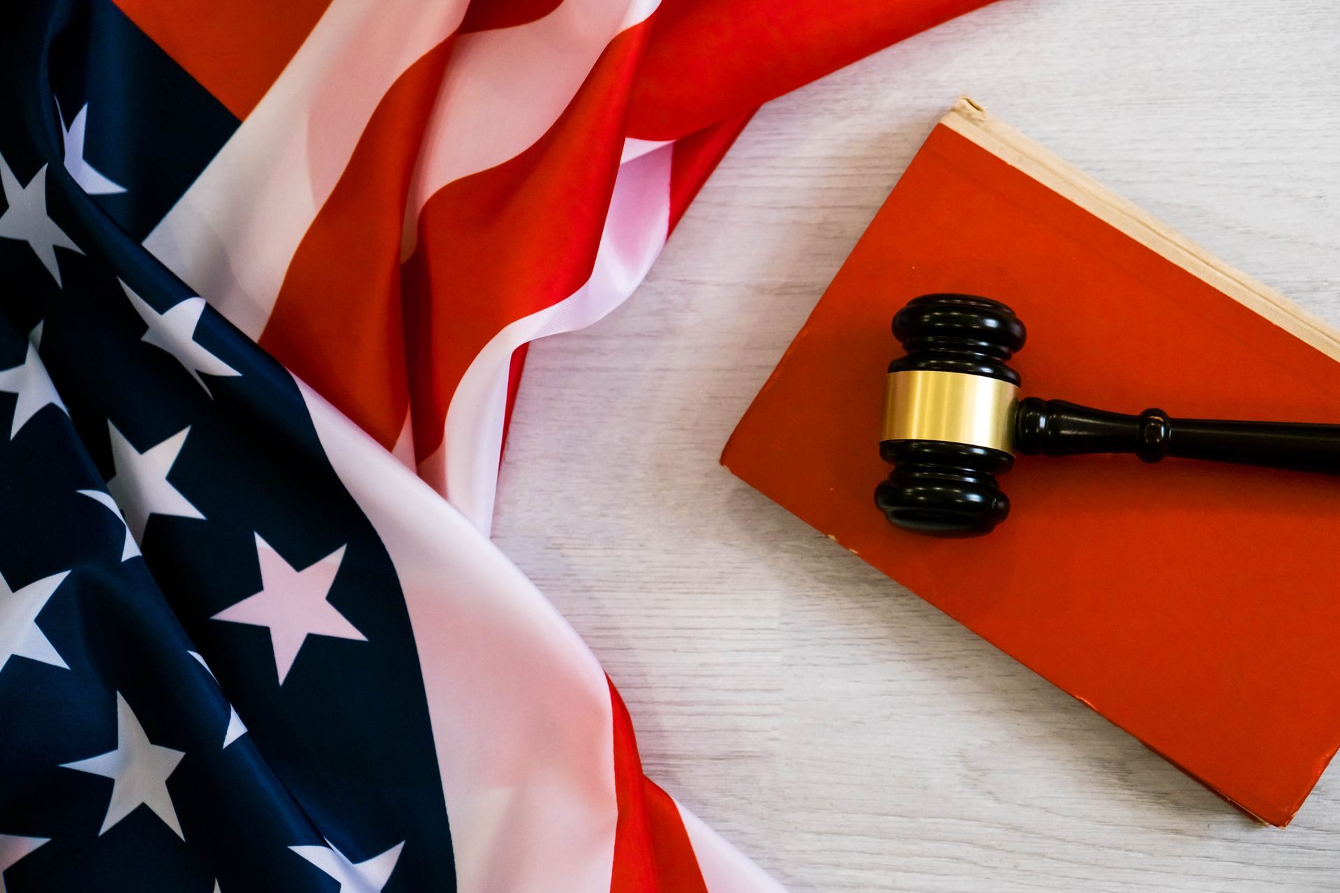 American flag with judgeās gavel resting on a red book or folder