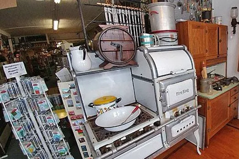 An old stove with pots and pans on it in a kitchen.