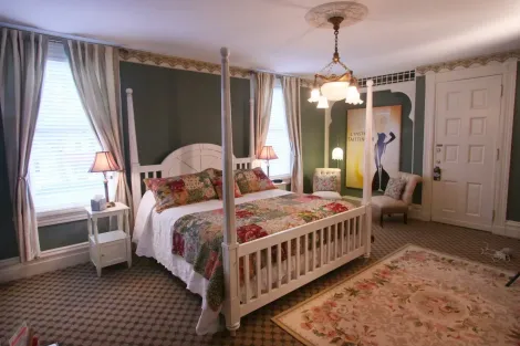 A bedroom with a four poster bed and a rug