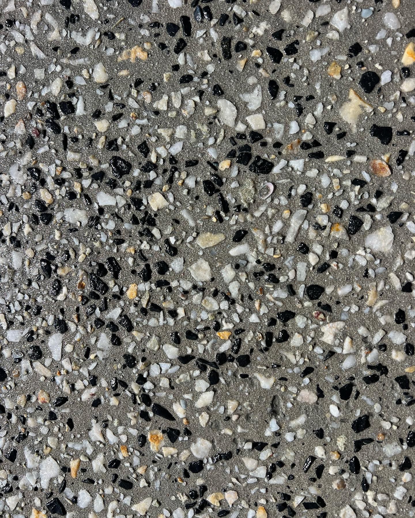 Gray speckled stone surface with black, white, and tan flecks