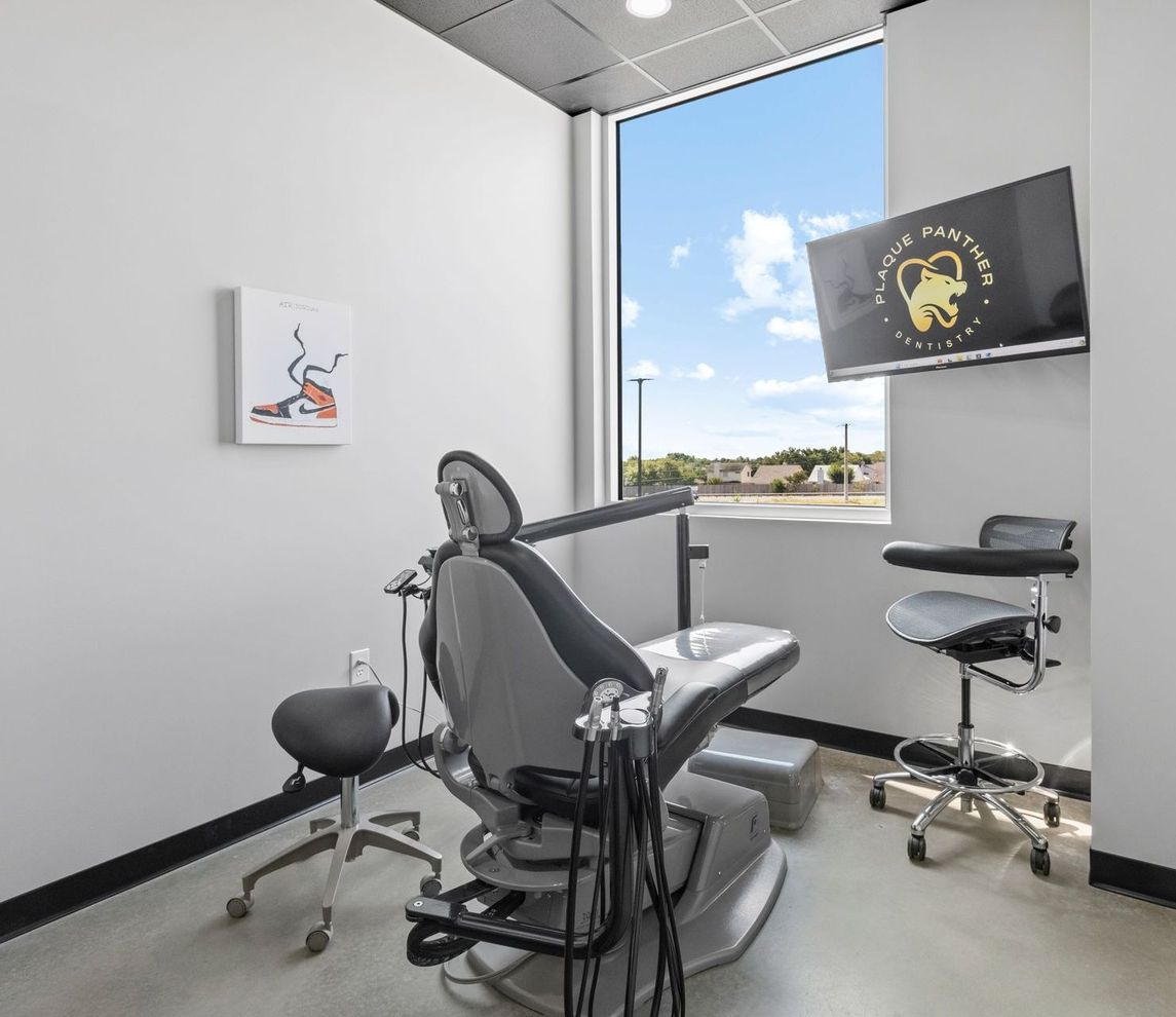 Dental examination room with chair, tools, and window.