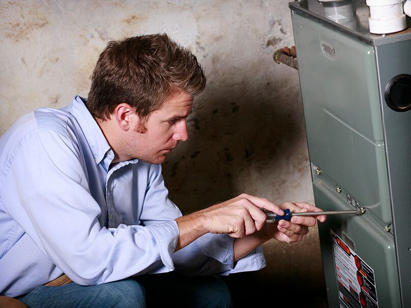 Man Screwing Furnace - New Castle, PA - Central Heating & Plumbing Man Screwing Furnace - New Castle, PA - Central Heating & Plumbing