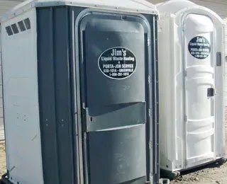 Two portable toilets are parked next to each other.