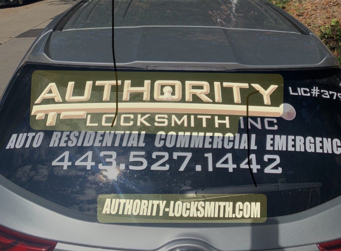 Authority Locksmith Inc phone number and website on the back window of a service car
