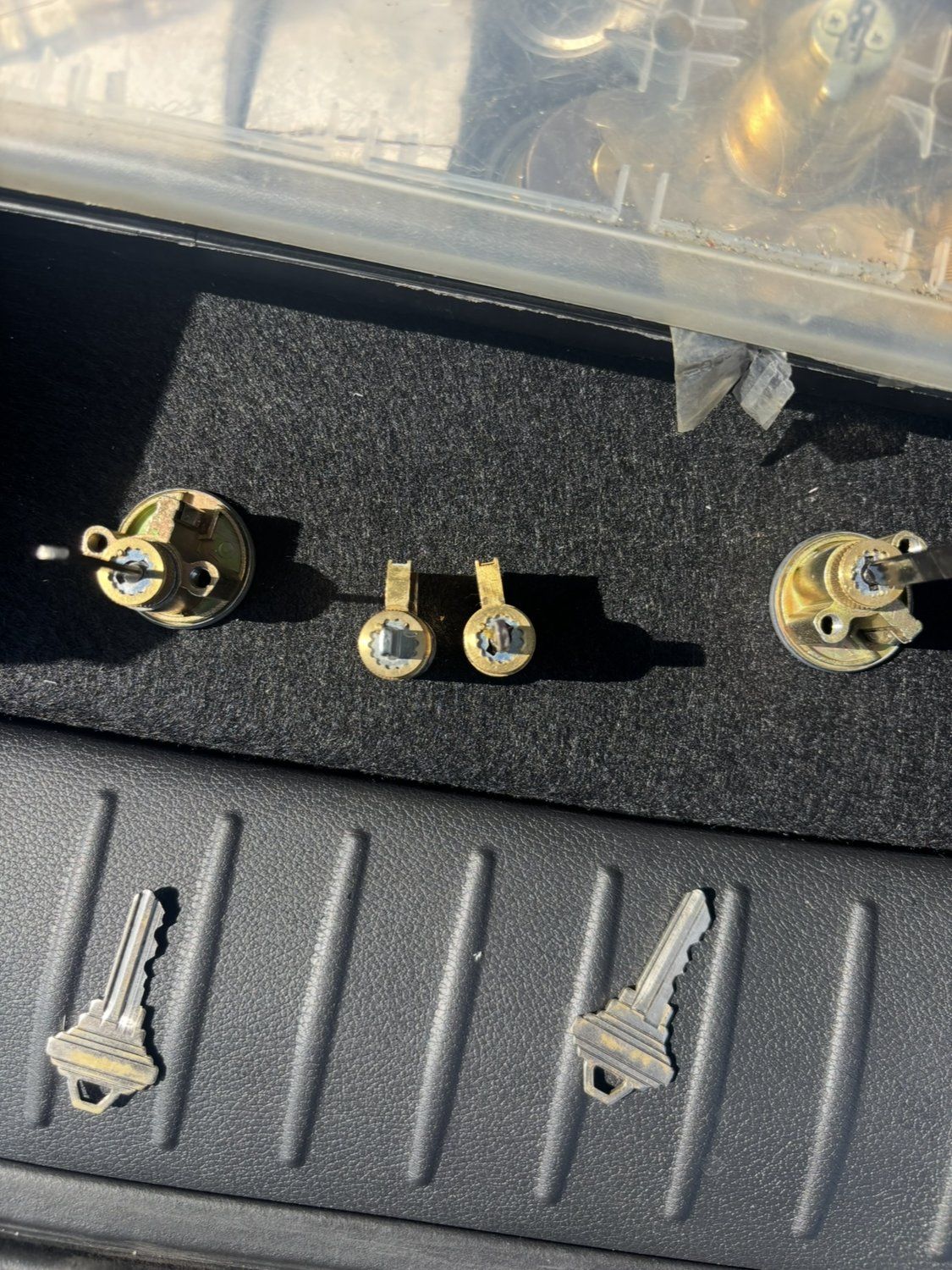 Door lock cylinders and two house keys on a work mat