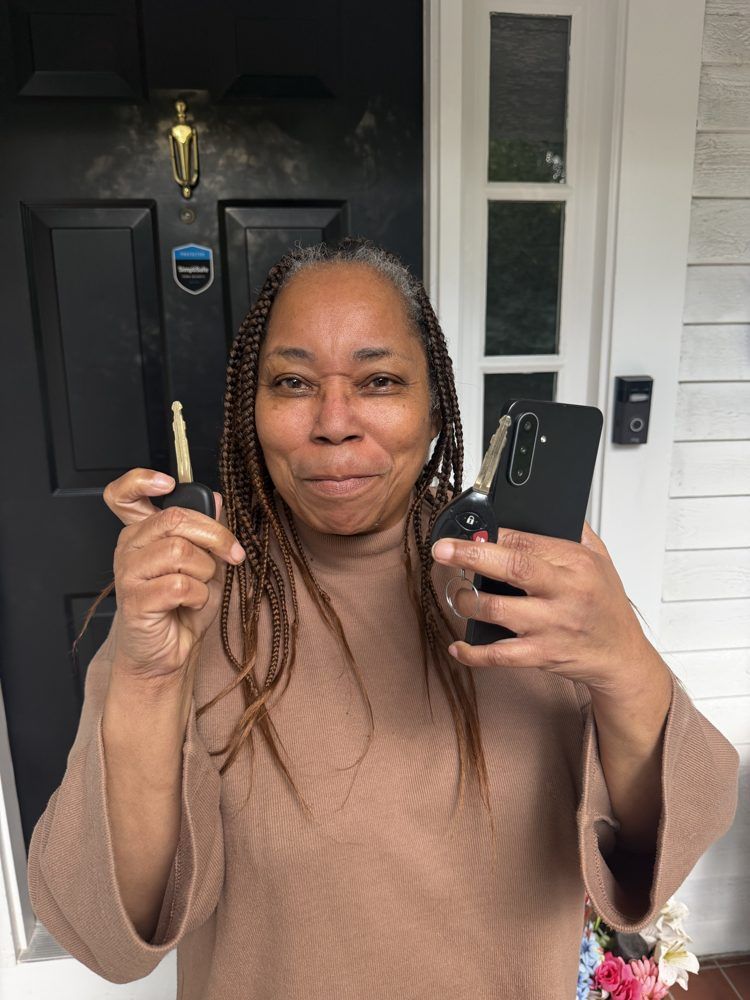 Customer smiling at her front door, holding up her new keys
