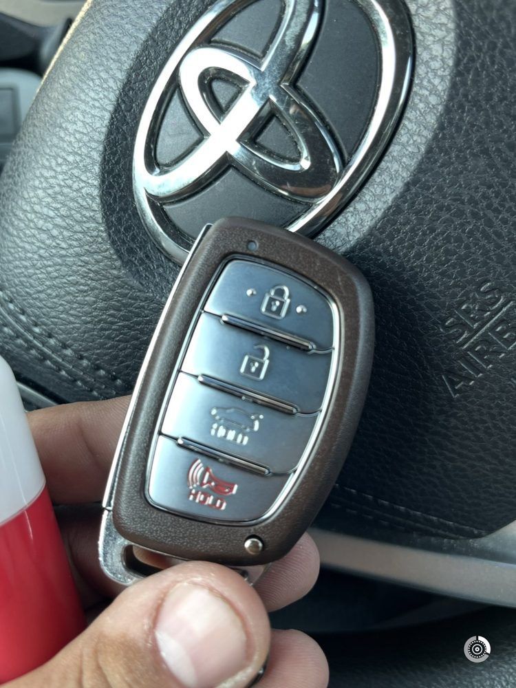 Smart key fob held up in front of a steering wheel