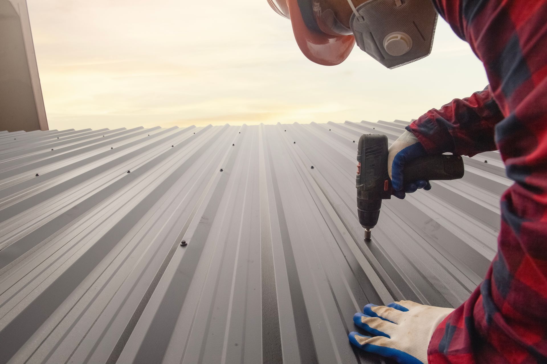 Roofing contractor repairs roof with electric screwdriver