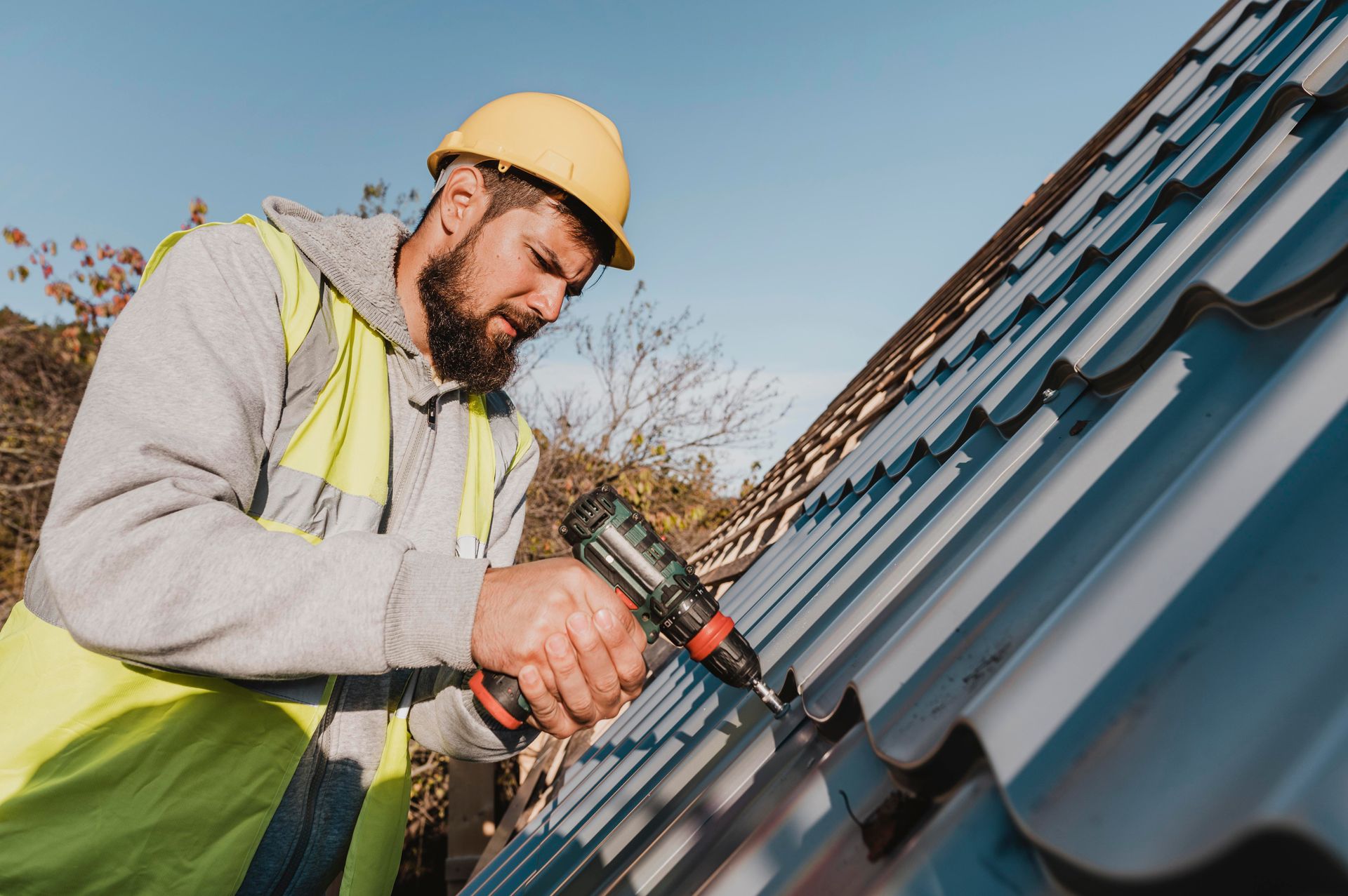 Roofing contractor installing asphalt shingle using a drill
