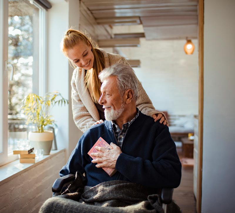Woman standing behind man sitting with hands on his shoulder