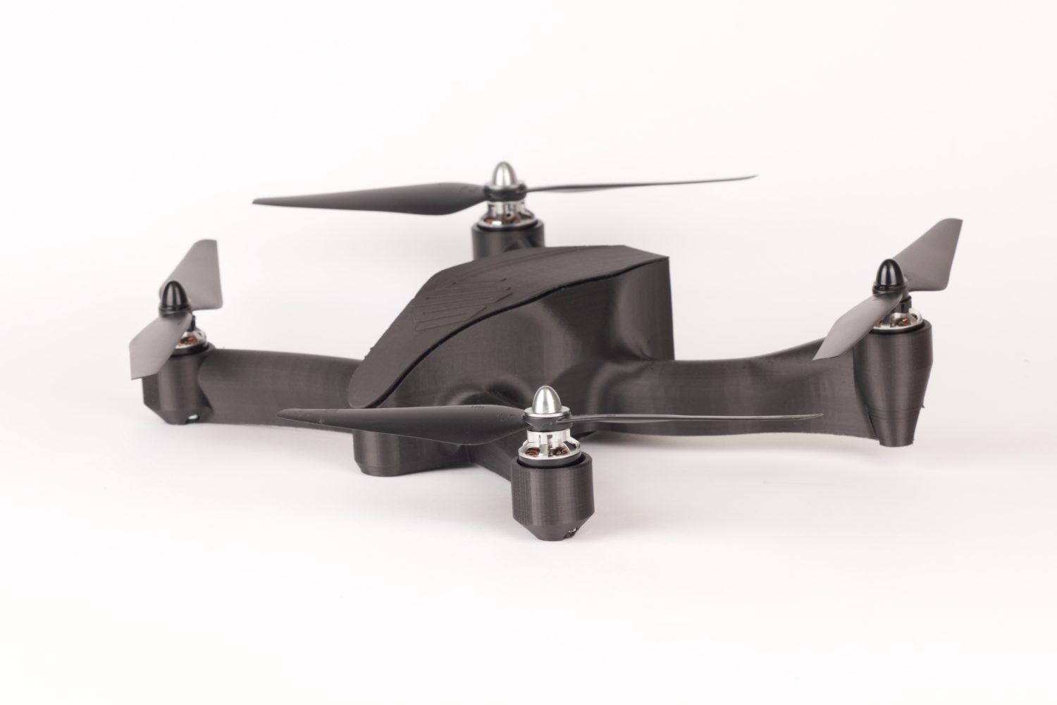 Black drone with four propellers, set against a white background.