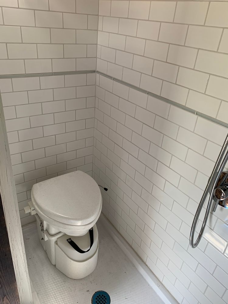 A White Toilet Is Sitting In A Bathroom Next To A Window — Evolution Solar Kingaroy in Kingaroy, QLD