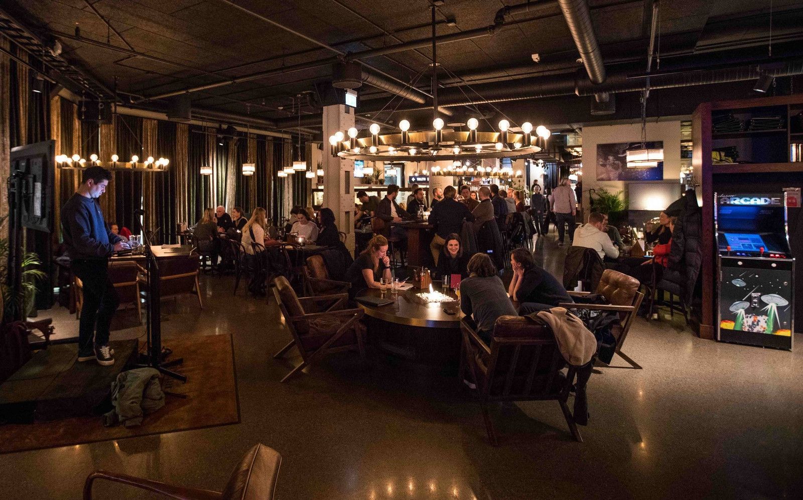 En gruppe mennesker sitter ved bordene på en restaurant.
