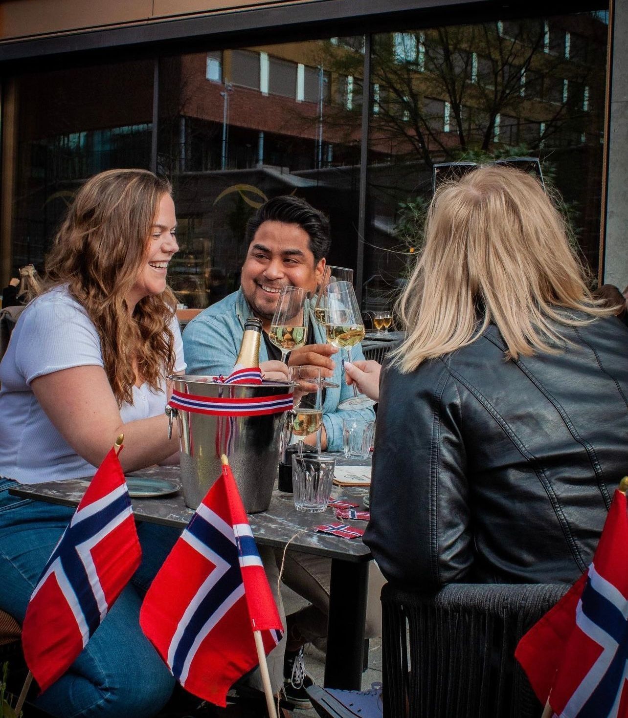 En gruppe mennesker sitter ved et bord med flagg på.