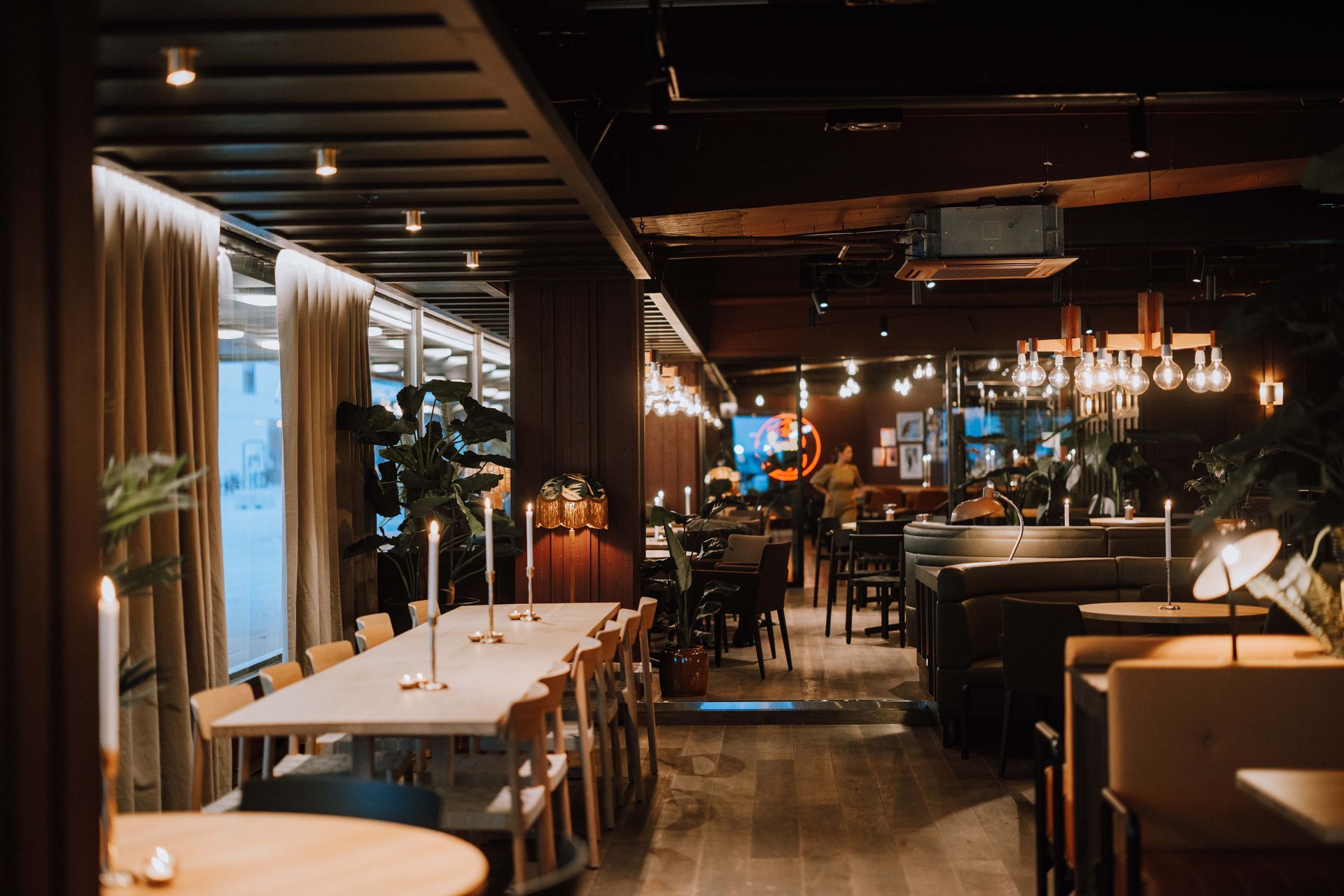 En restaurant med bord og stoler og en bar