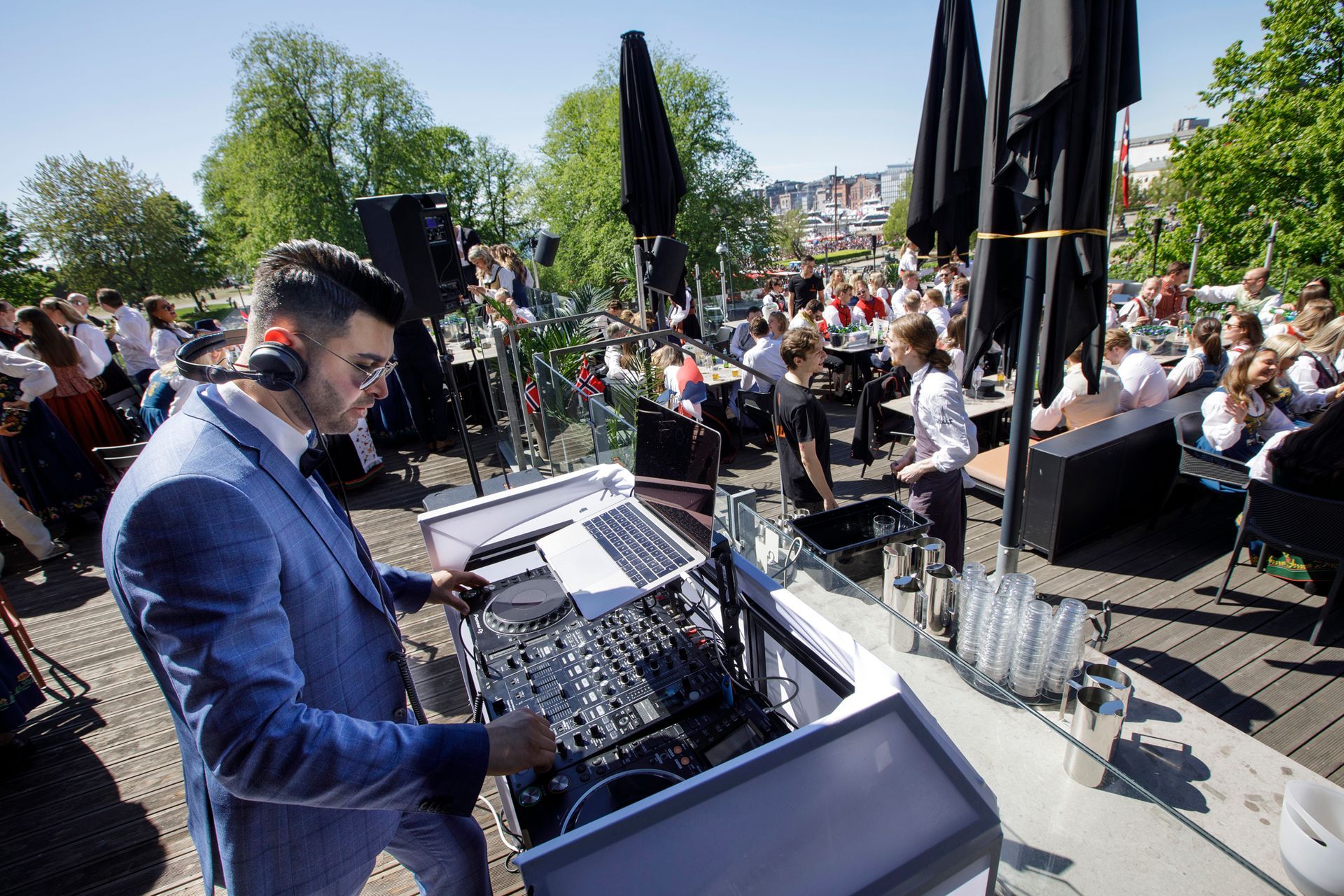 En mann i dress og hodetelefoner spiller musikk på en fest.