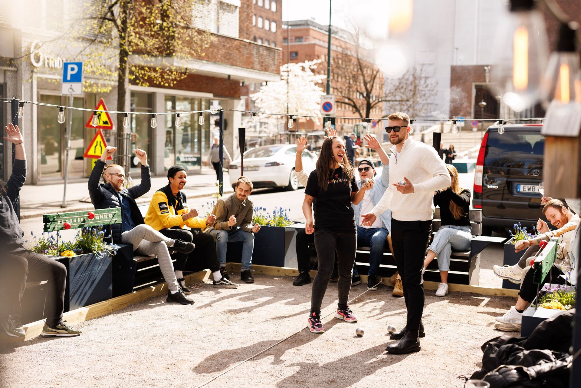 En gruppe mennesker sitter på en benk og danser på Amundsen Bryggeri og Spiseri ved Rådhuset i Oslo.