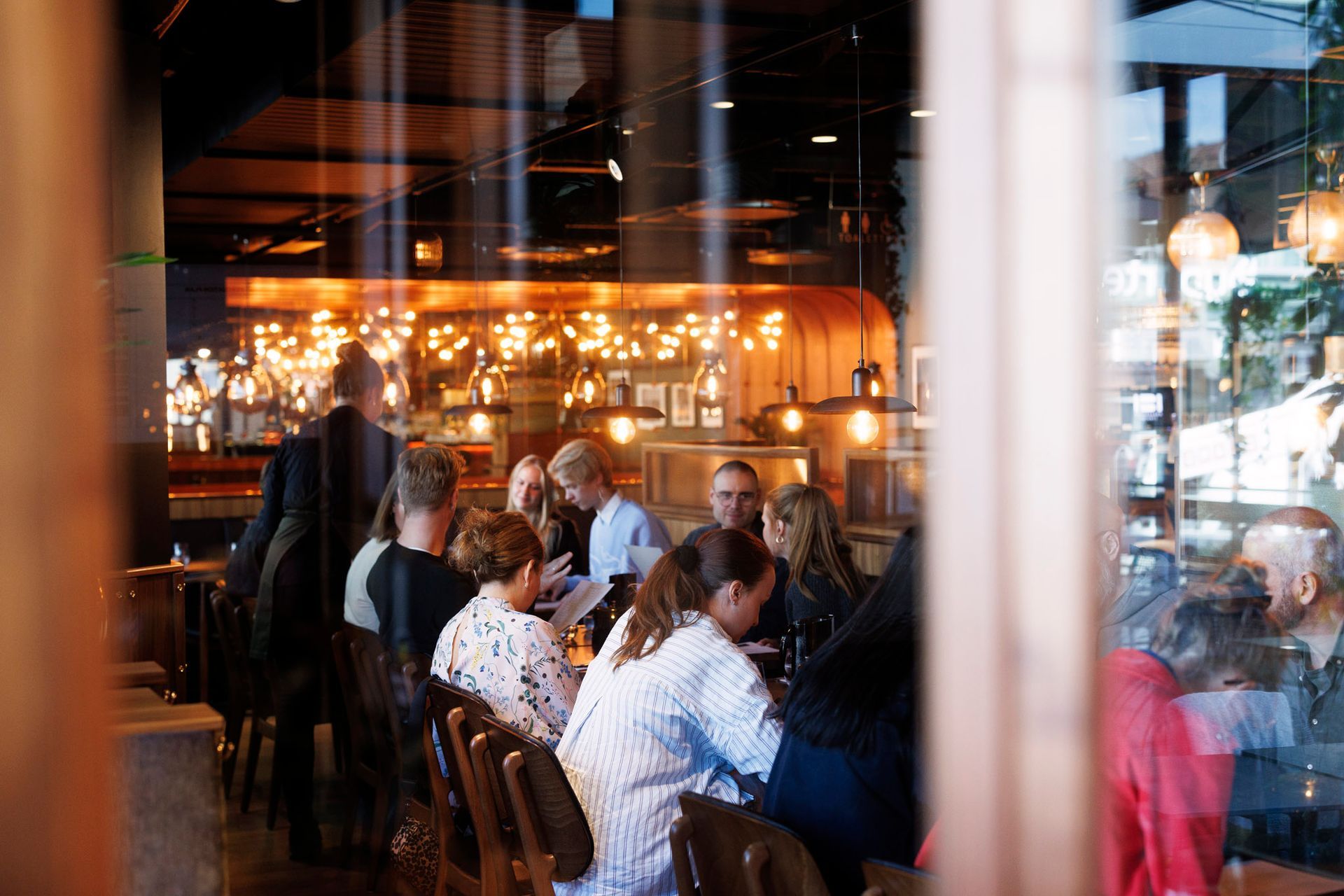 En restaurant med bord og stoler og en bar