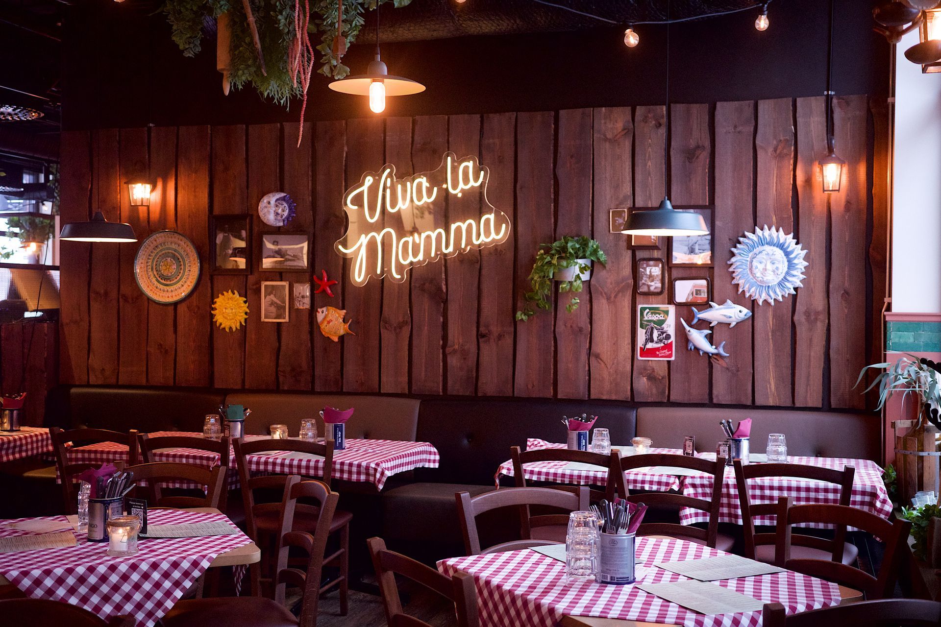 En restaurant med bord og stoler og et skilt hvor det står viva la mamma