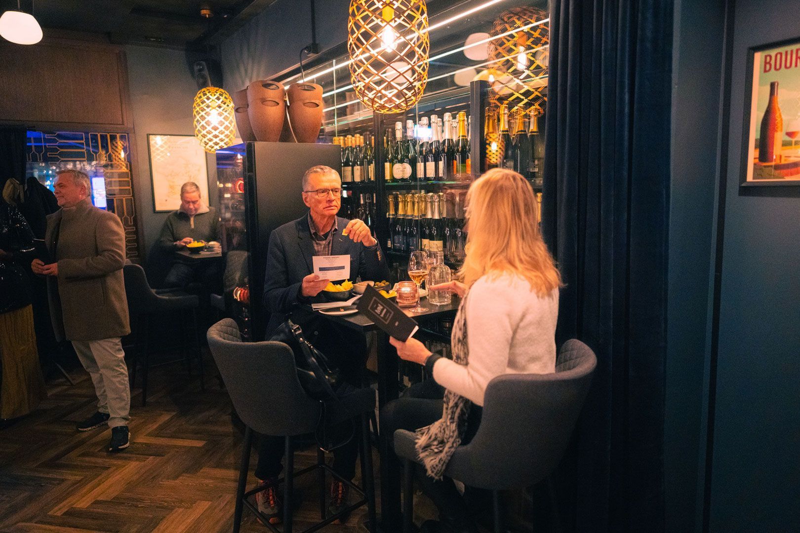 En mann og en kvinne sitter ved et bord i en bar og ser på menyer.