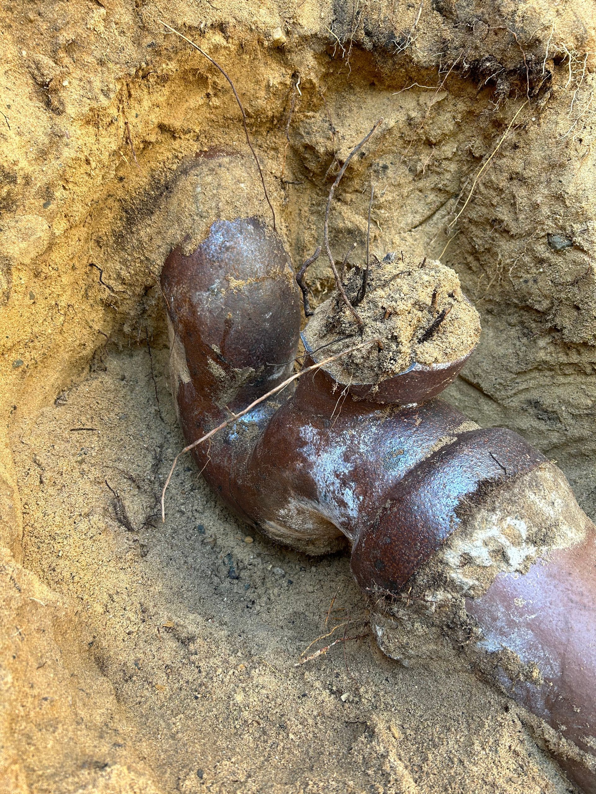 A close up of a pipe in the dirt.