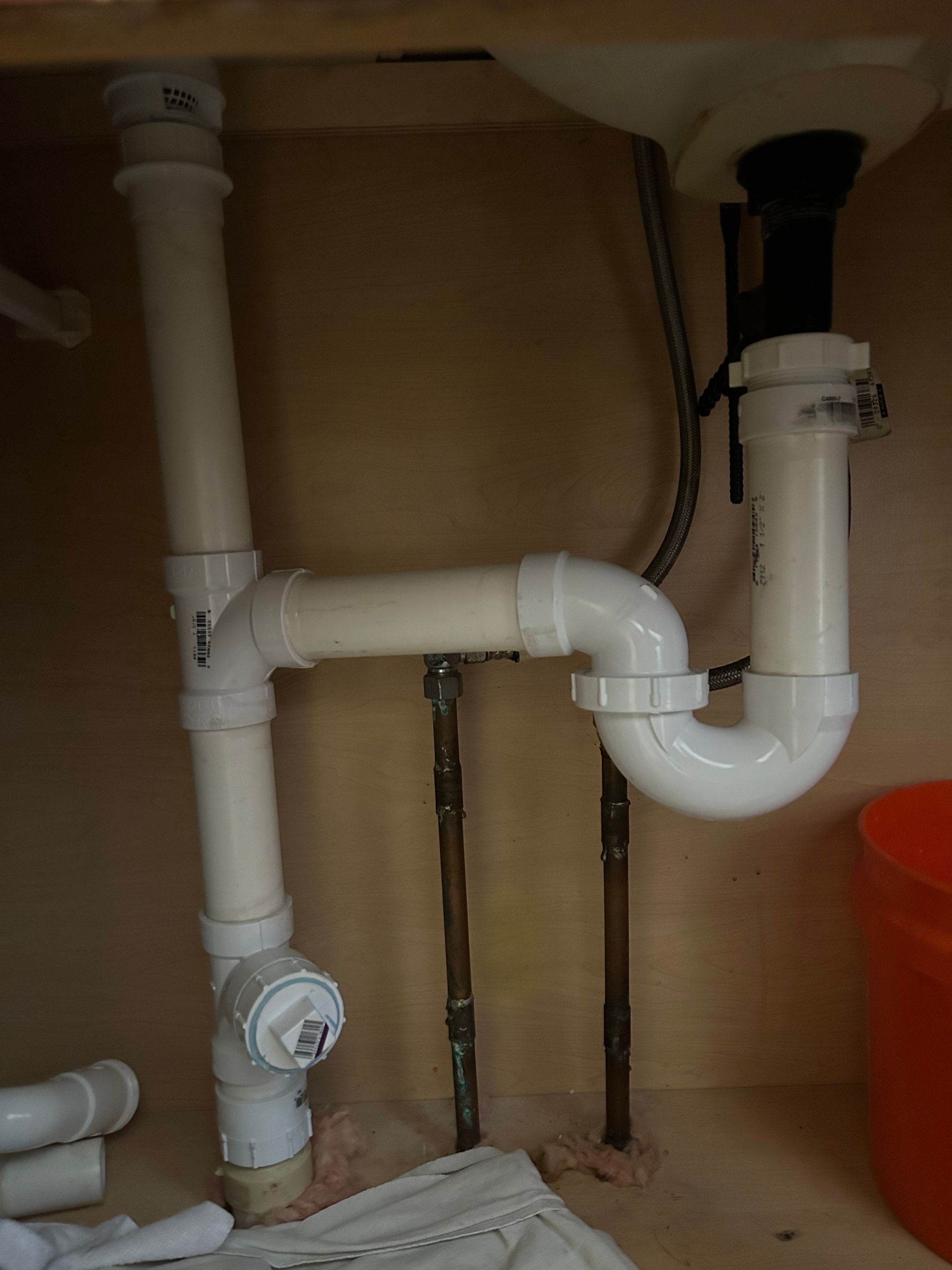 A sink with a lot of pipes underneath it