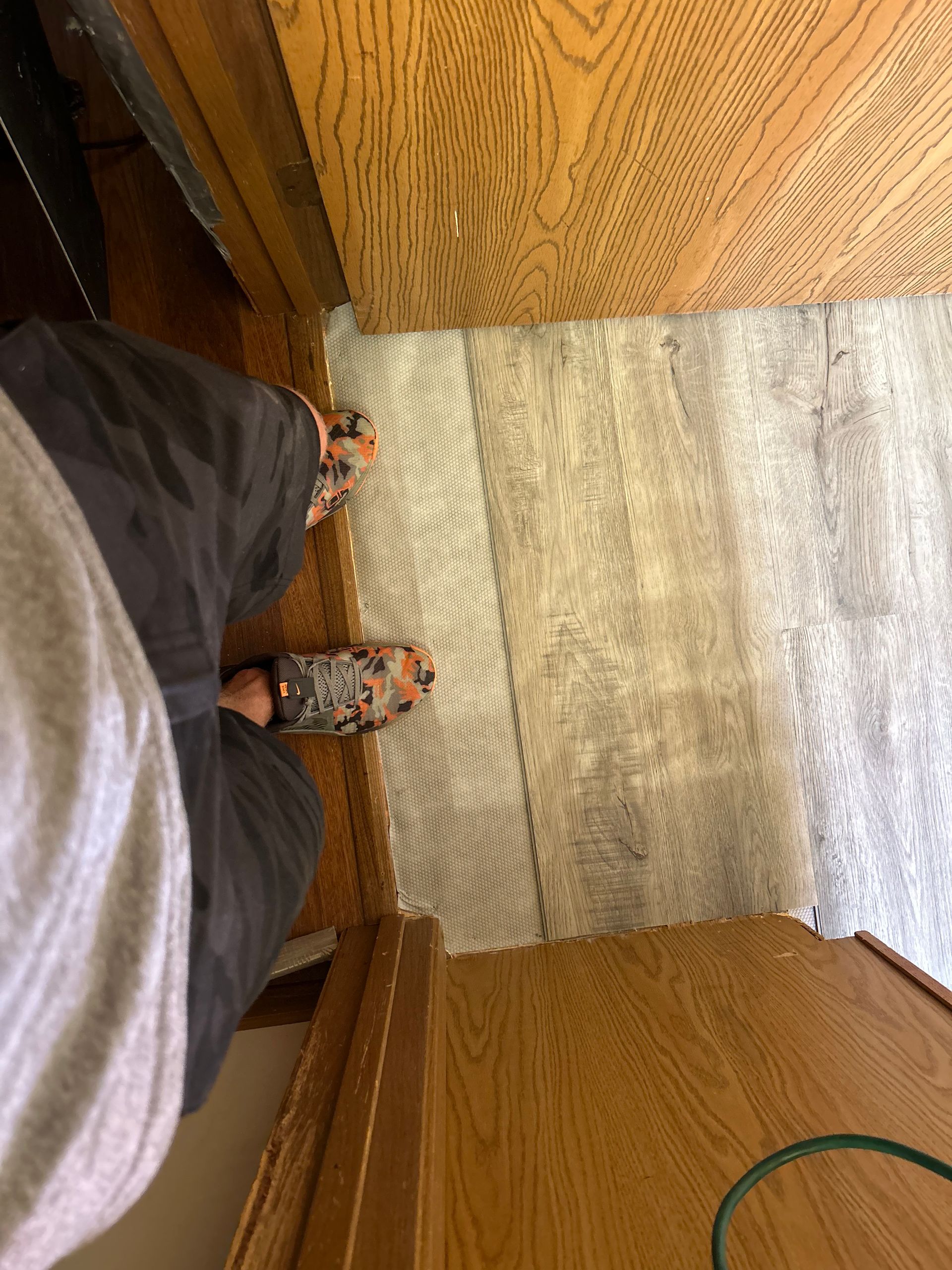 A person is standing on a rug next to a door.