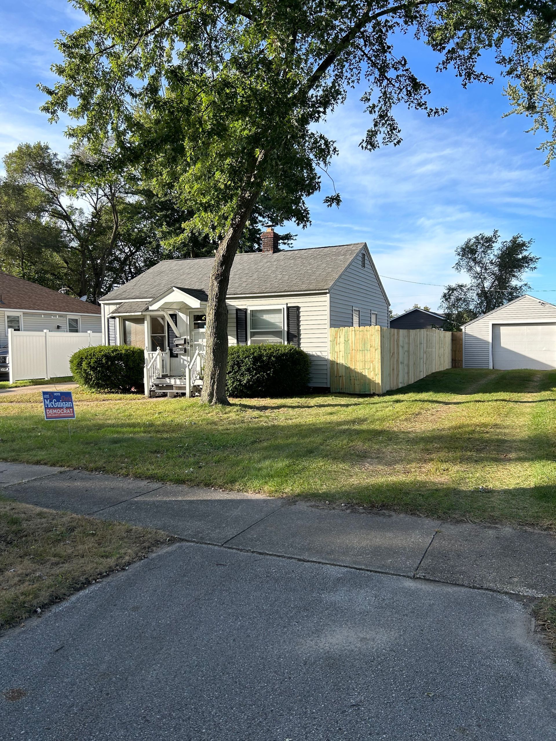 A white house with a wooden fence in front of it