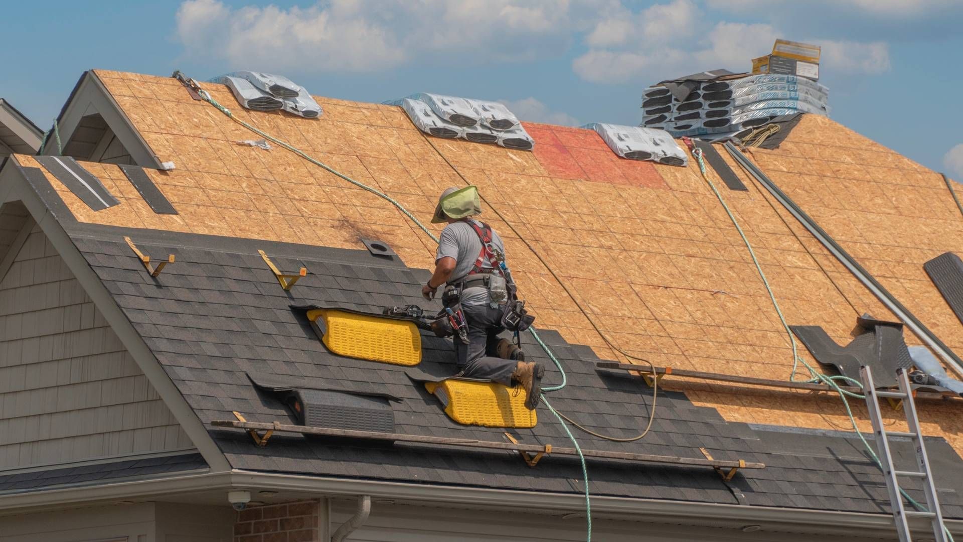 A man is working on the roof of a house.