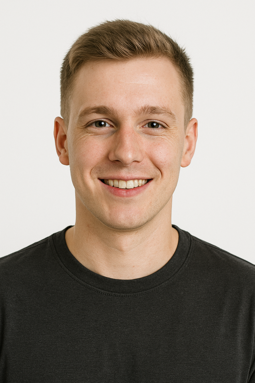 A young man in a black sweater is smiling for the camera.
