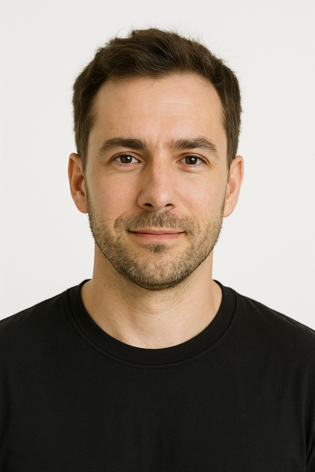 A man with a beard is wearing a black shirt and smiling for the camera.
